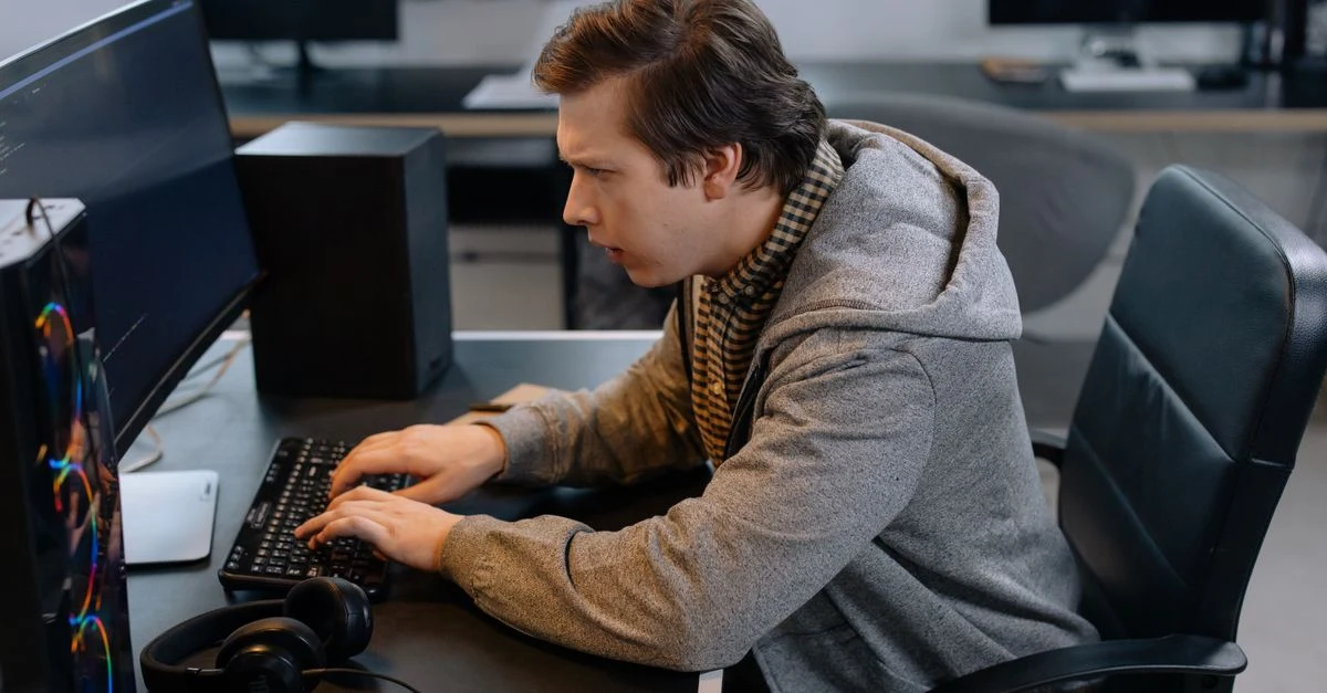 Male healthcare professional reviewing cardiology CPT coding on desktop monitor in medical office workspace.