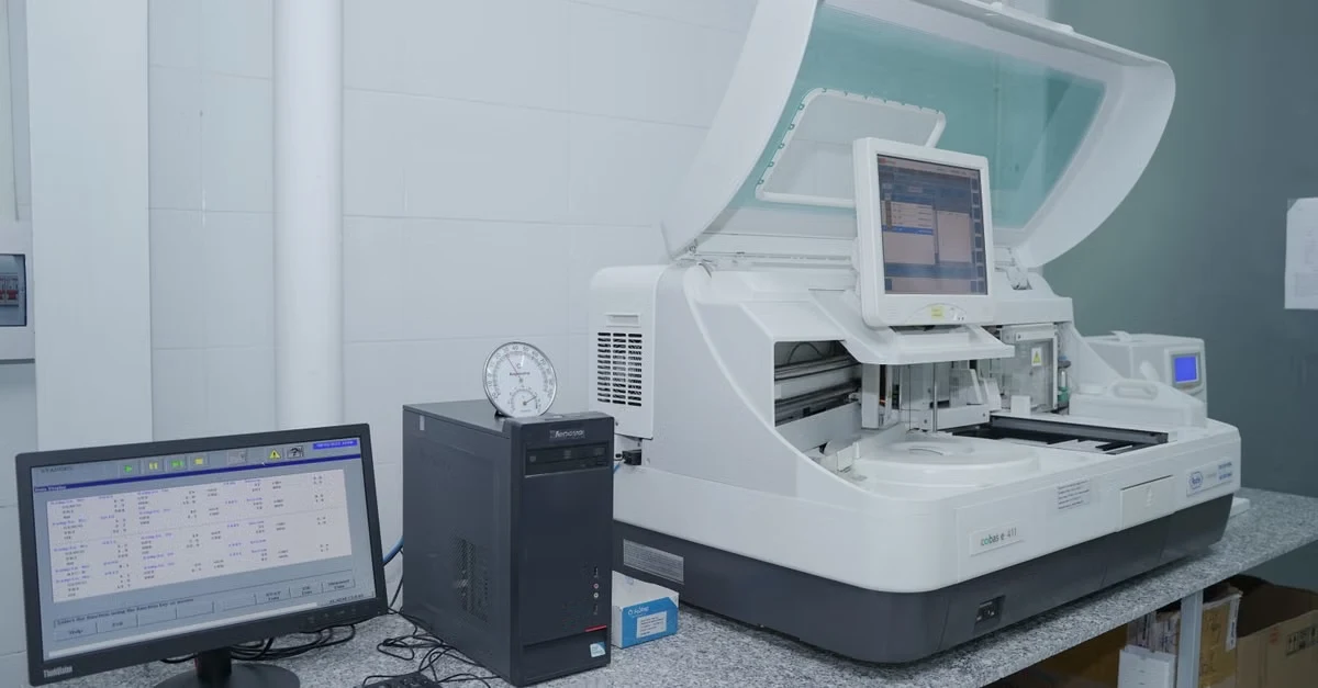 Automated clinical analyzer with monitor displays orthopedic coding accuracy testing in medical laboratory setting.