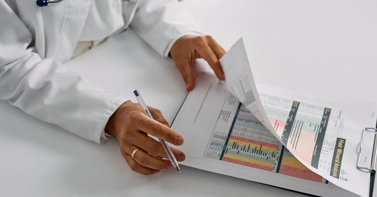 Doctor reviewing medical coding compliance charts and documentation with stethoscope visible, analyzing healthcare records.