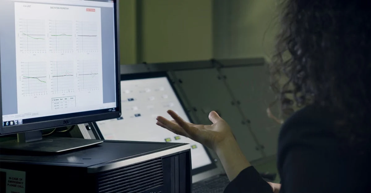 Developer reviewing hand surgery coding wireframes on desktop monitor with documentation reference nearby.