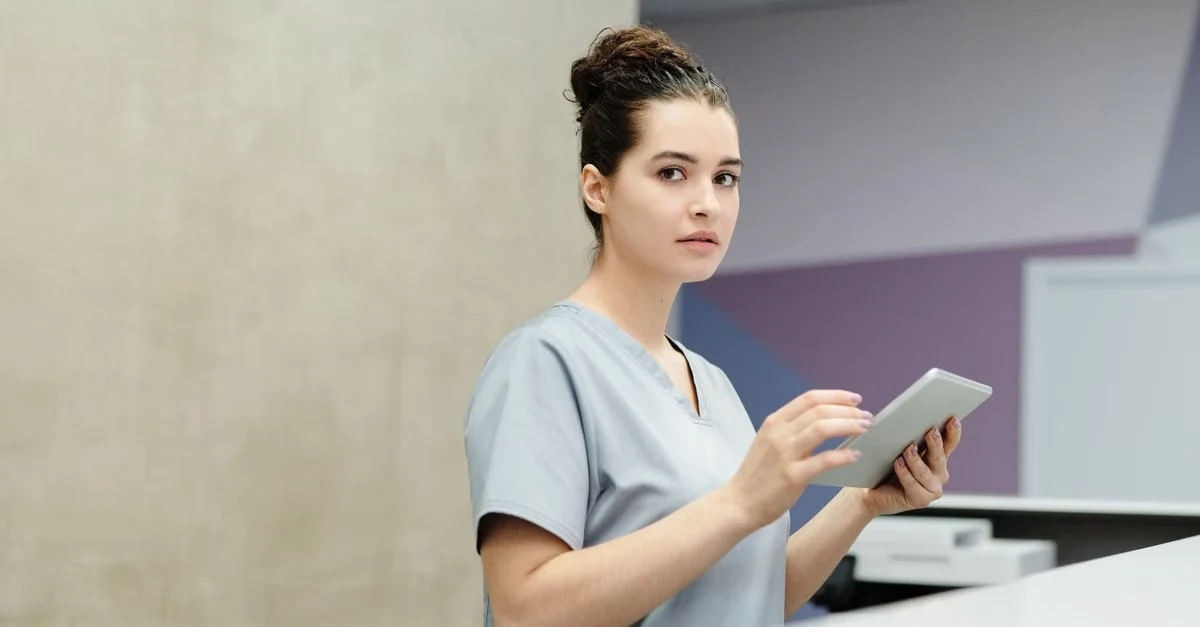 Healthcare worker holding tablet reviewing agentic AI healthcare solutions in modern clinical setting.