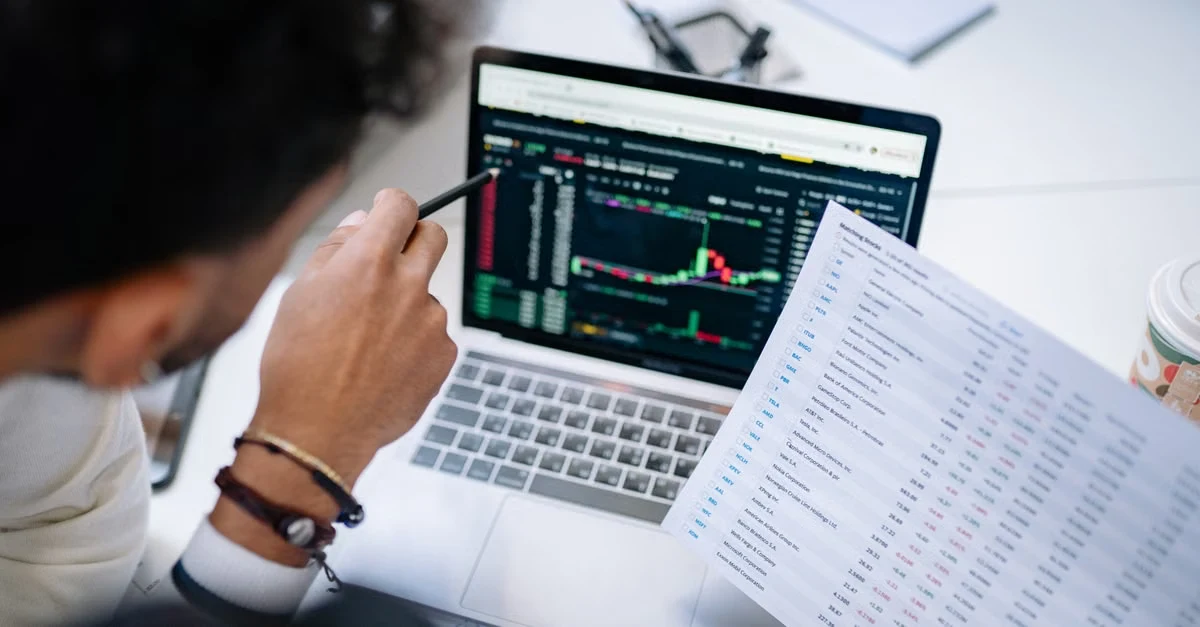 Analyst reviewing revenue cycle management automation dashboard with live charts and financial data spreadsheet on laptop.