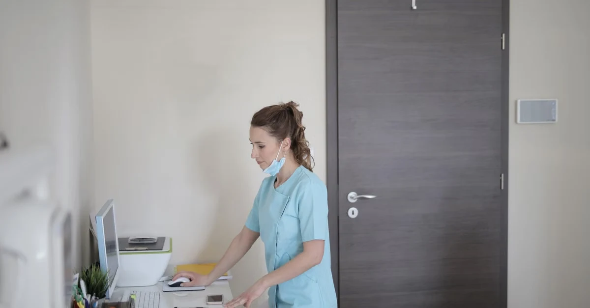 Healthcare provider using ambient clinical documentation at desk in modern medical office.