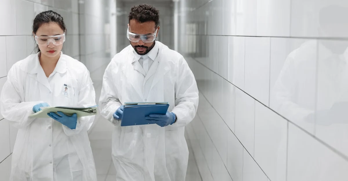 Two healthcare professionals in lab coats reviewing medical records to improve healthcare charge capture accuracy.