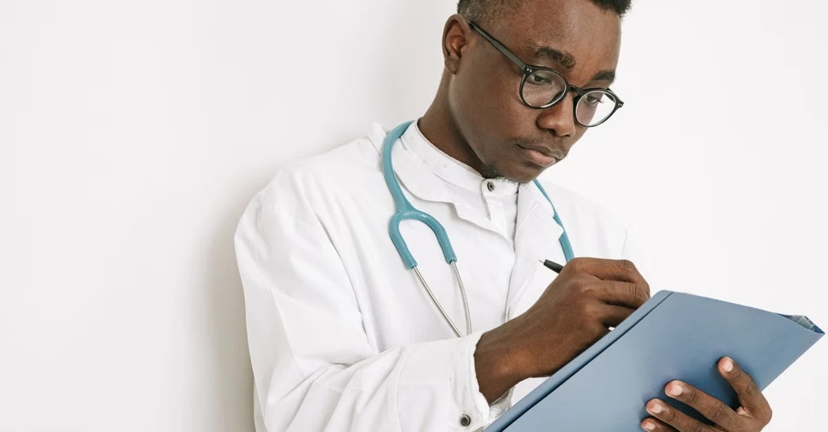 Doctor in white coat and stethoscope reviewing patient data on tablet for healthcare revenue cycle management.