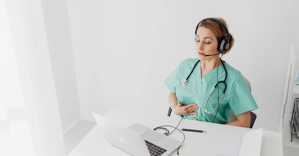 Healthcare professional evaluating Nuance DAX alternatives at desk with headset and laptop.