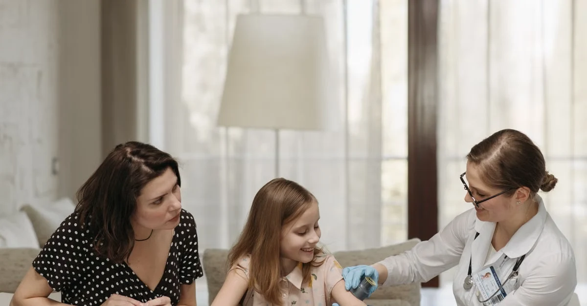 Doctor using AI scribe pediatrics tool during child consultation with parent present in clinical examination room.