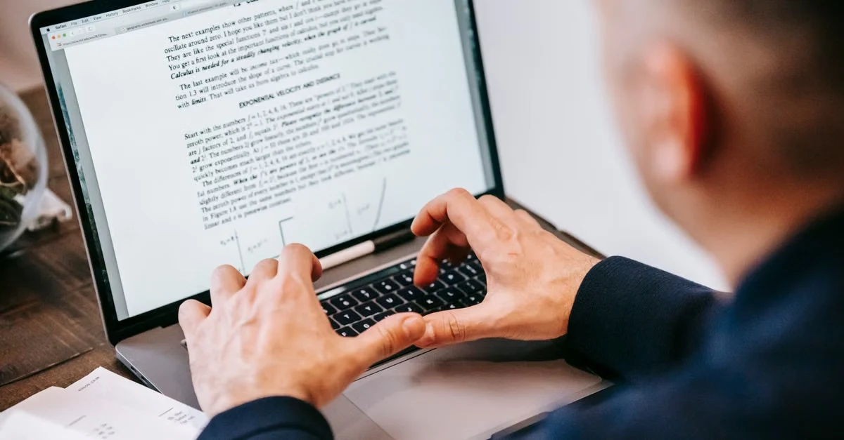 Professional writing AI SOAP notes on laptop keyboard for concise clinical documentation.